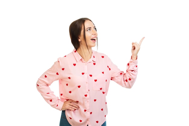 Young beautiful girl isolated on a white background points his fingers at the place for promo offers or advertising