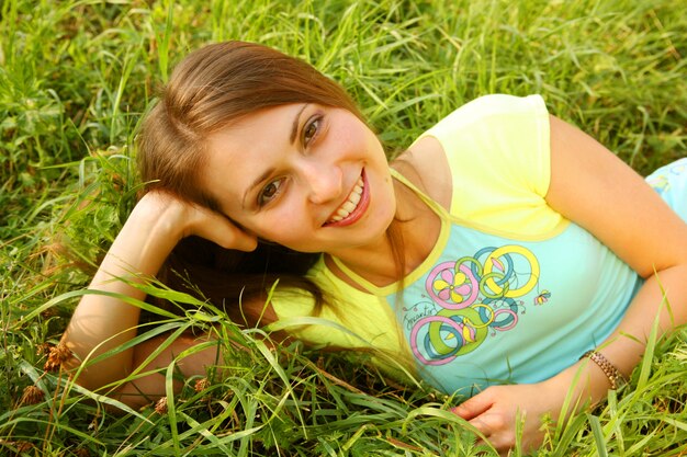 young beautiful girl lays on a grass 