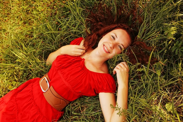 Young beautiful girl lays on a grass