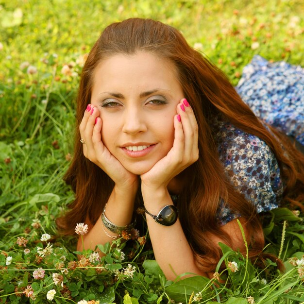 Young beautiful girl lays on a grass