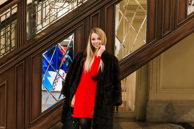 Young beautiful girl in a mink coat in gum on red square is shopping, an indoor market, Moskva