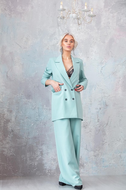 Young beautiful girl model blonde with hair and makeup in a fashionable suit with a jacket