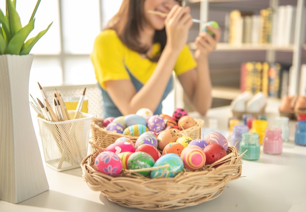 Young beautiful girl paint color on easter egg