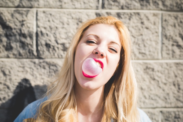Photo young beautiful girl playing with bubblegum