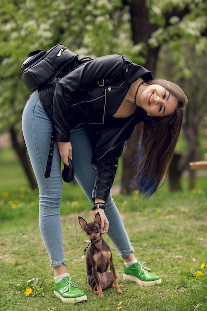 屋外の犬と遊ぶ美しい少女