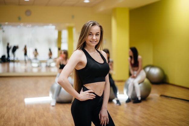 Young beautiful girl posing after group sessions in the gym. Healthy lifestyle