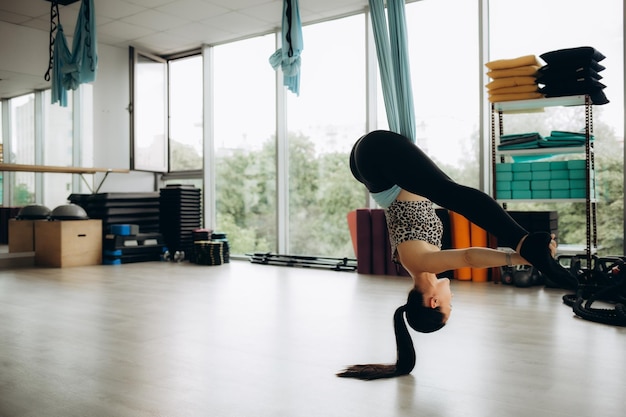 Photo young beautiful girl practicing aerial yoga in gym high quality photo