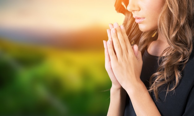 A young beautiful  girl praying on blurs background