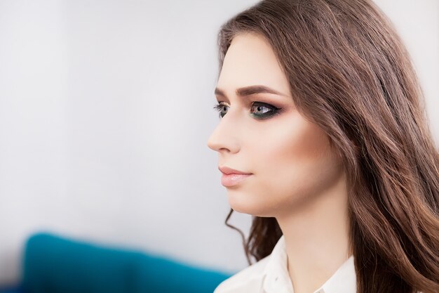 Young, beautiful girl put on make-up in a beauty salon