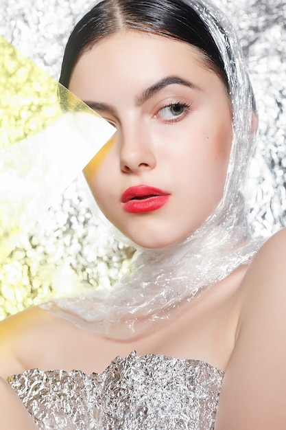 Young beautiful girl in a silver dress