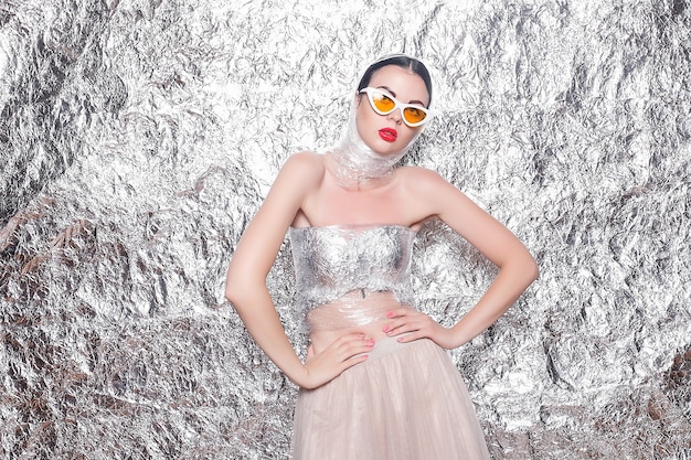 Young beautiful girl on a silver surface