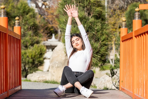 Una giovane bella ragazza seduta per terra e tenendola in alto foto di alta qualità