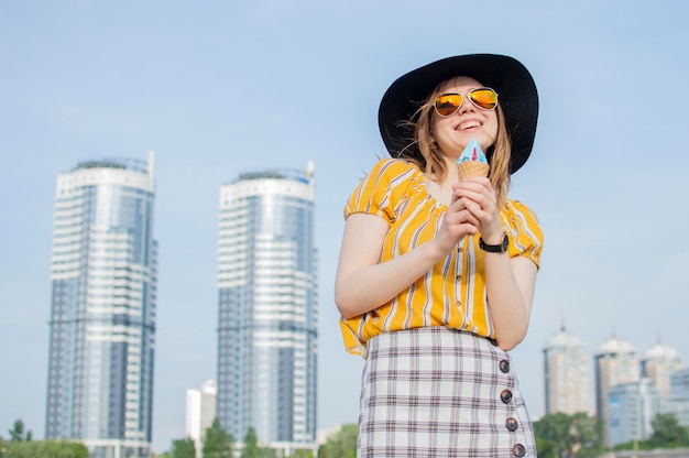 Young beautiful girl standing on the beach in a yellow striped Tshirt in orange glasses