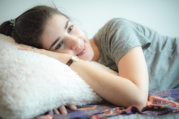 Photo young and beautiful girl taking nap during a day, she had a sweet dream and relaxing then smiling showing up on her face, lifestyle at home concept, sleeping on the sofa, chilling and cozy house.