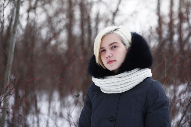 Young beautiful girl on a walk in a winter park