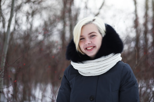 Young beautiful girl on a walk in a winter park