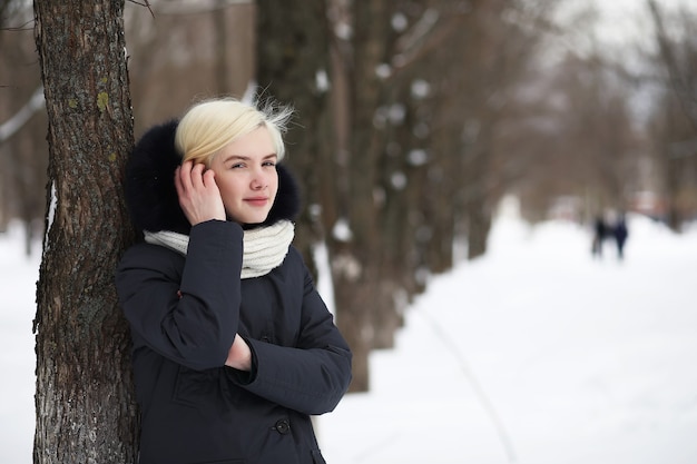 Young beautiful girl on a walk in a winter park