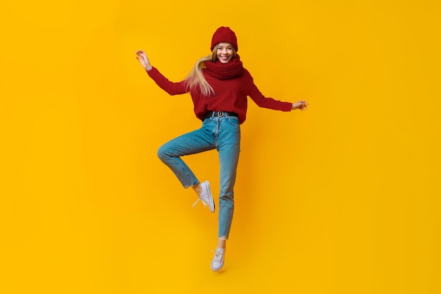 Young beautiful girl in warm clothes jumping up