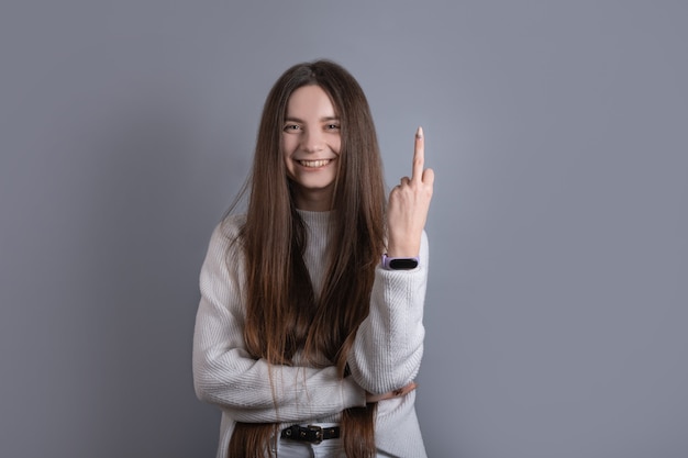 Young beautiful girl wearing casual sweater showing middle finger doing fuck you bad expression, provocation and rude attitude.