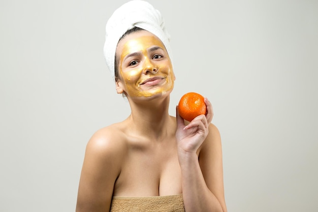 Young beautiful girl in a white towel on his head wears collagen gel patches under her eyes