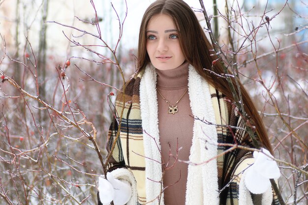 Young beautiful girl in winter snowy day outdoors