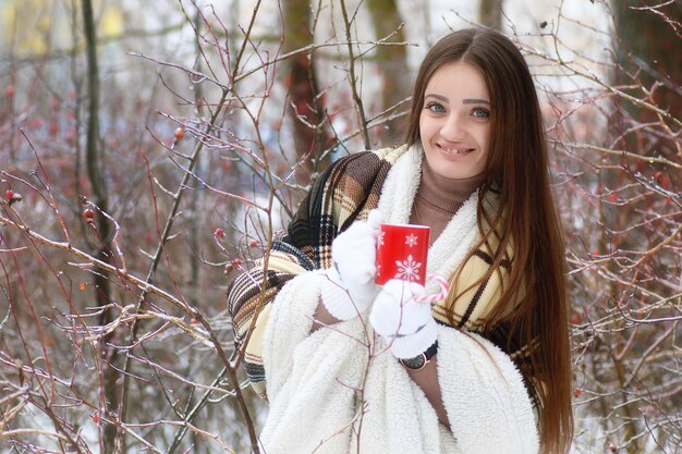 Young beautiful girl in winter snowy day outdoors