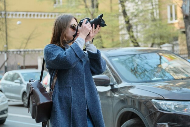 Young beautiful girl with camera in the spring city