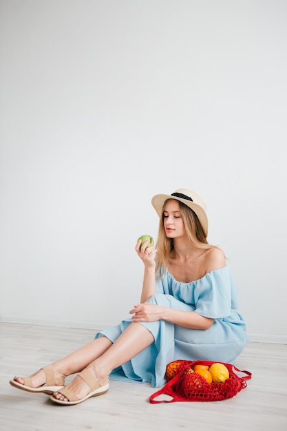 Young beautiful girl with fresh fruit in a string bag. The concept of zero waste. Toning.