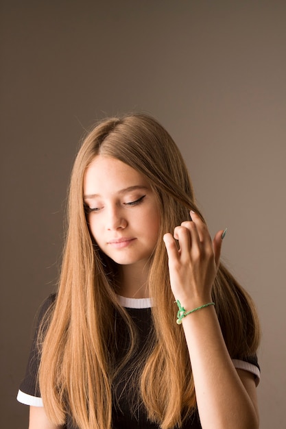 Una giovane bella ragazza con lunghi capelli biondi che guarda dal basso, il concetto è imbarazzo