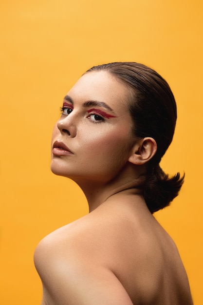 Photo young beautiful girl with makeup on a yellow background