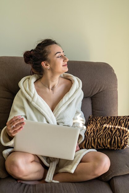 young beautiful girl working on a laptop in bed during quarantine. The concept of work in quarantine