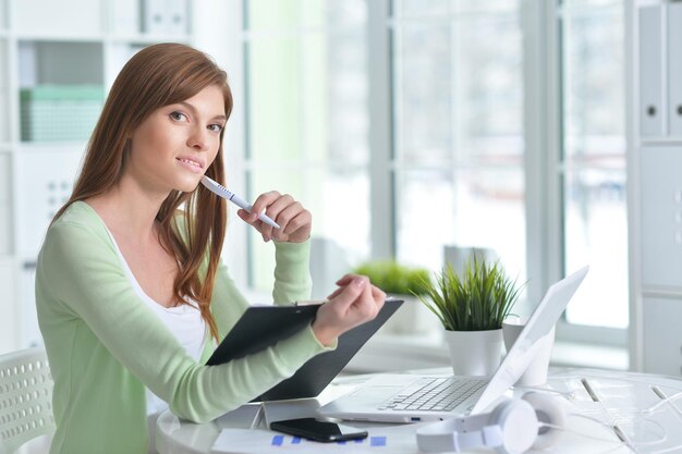 Giovane bella ragazza che lavora a un laptop