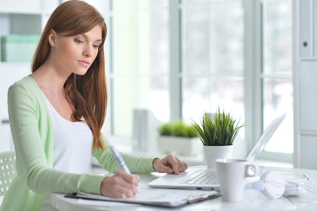 Young beautiful girl working at a laptop