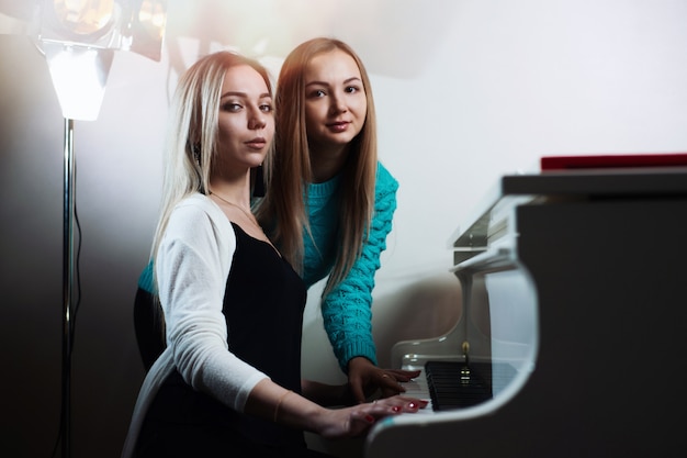 Young beautiful girls playing the piano.