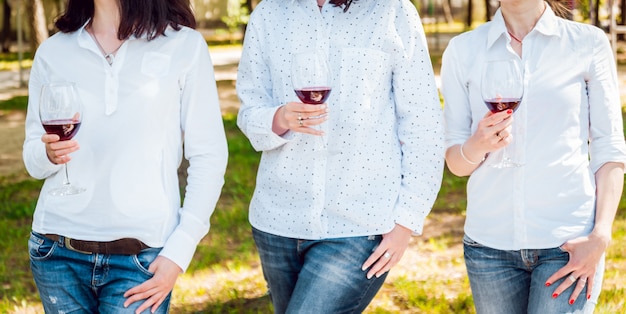 写真 公園で赤ワインのグラスを持つ美しい少女