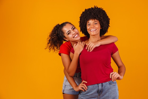 Young beautiful and happy afro female friends smiling to the camera.