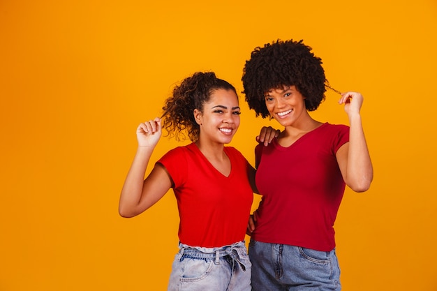 Young beautiful and happy afro female friends smiling to the camera