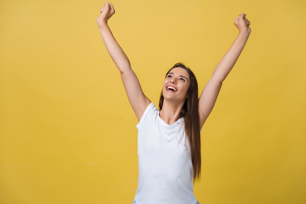 Young beautiful happy girl portrait isolated on yellow background.