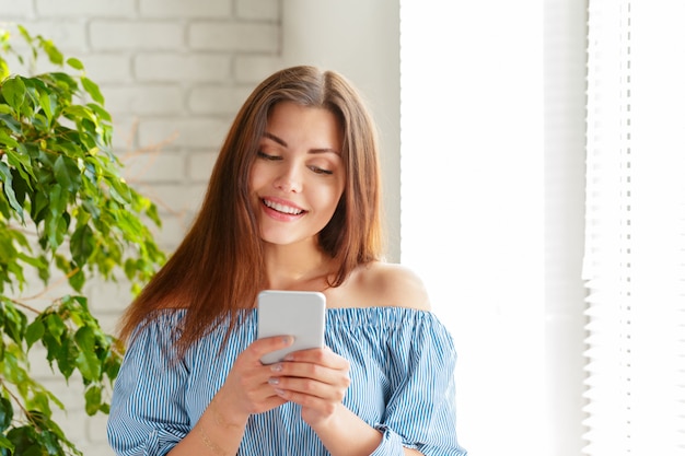 Young beautiful happy woman using smart phone.