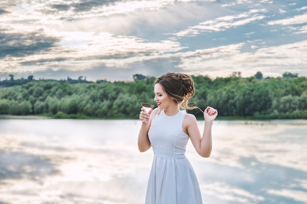 Photo young beautiful happy woman in white dress celebrates bachelorette party at the pier