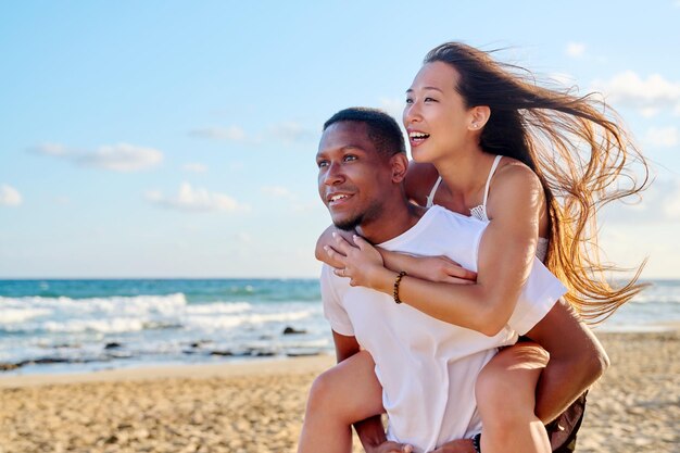 Young beautiful having fun couple on the sea background