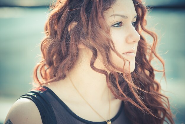 молодая красивая женщина хипстер с красными вьющимися волосами