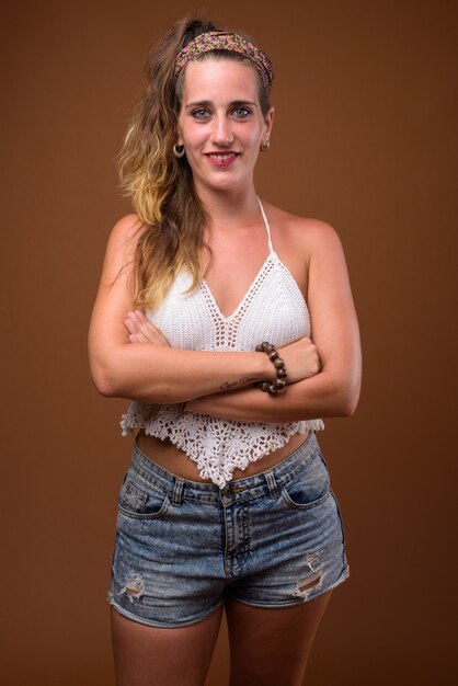 Young beautiful Hispanic woman against brown background