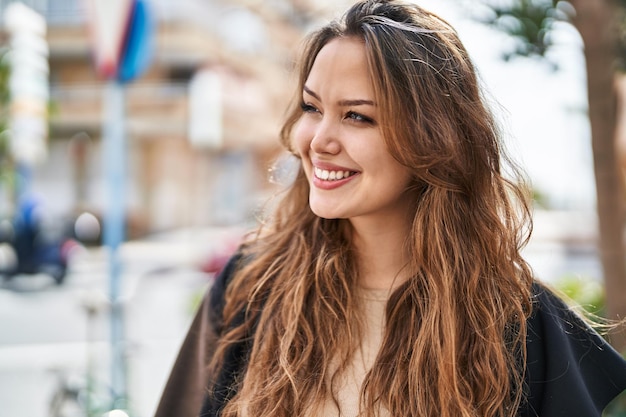 Young beautiful hispanic woman smiling confident looking to the side at street