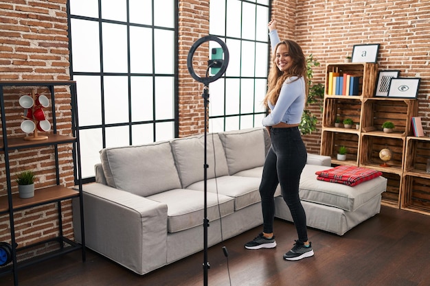 Young beautiful hispanic woman smiling confident recording tutorial dancing at home