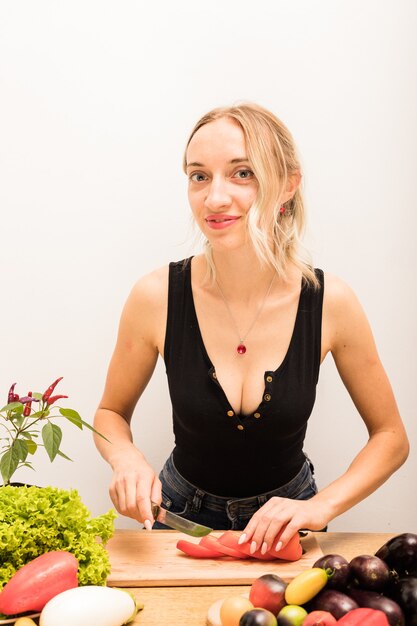 Young beautiful housewife is busy preparing healthy food at home in the kitchen