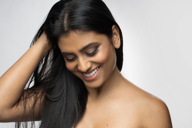 Young and beautiful Indian woman is very happy with her healthy long black hair