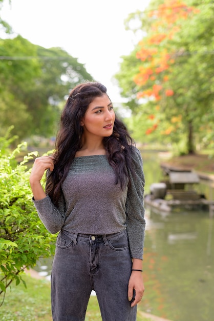 Young beautiful Indian woman thinking at the park outdoors