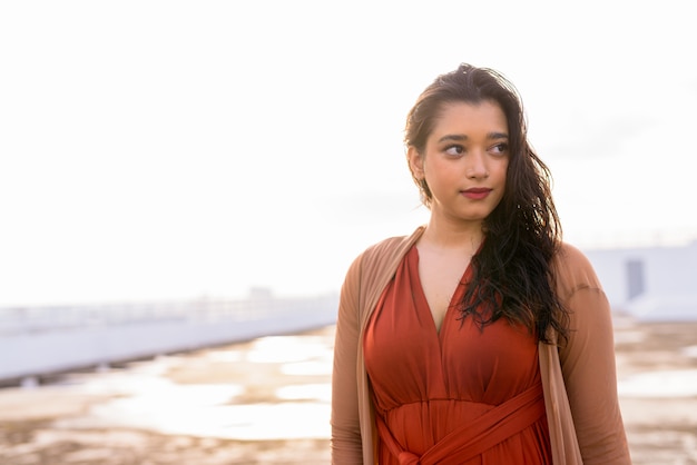 Young beautiful Indian woman thinking at rooftop of the building