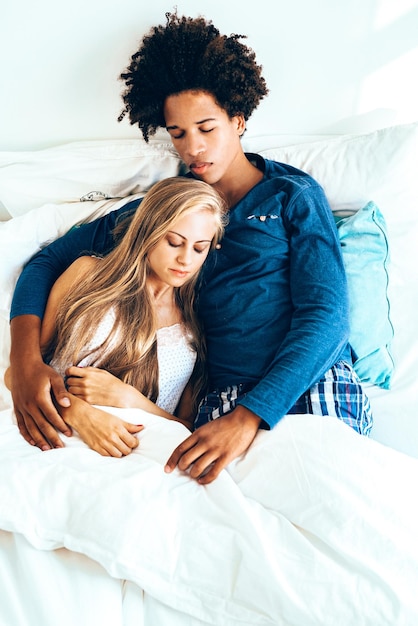 Young beautiful interracial couple in bed sleeping